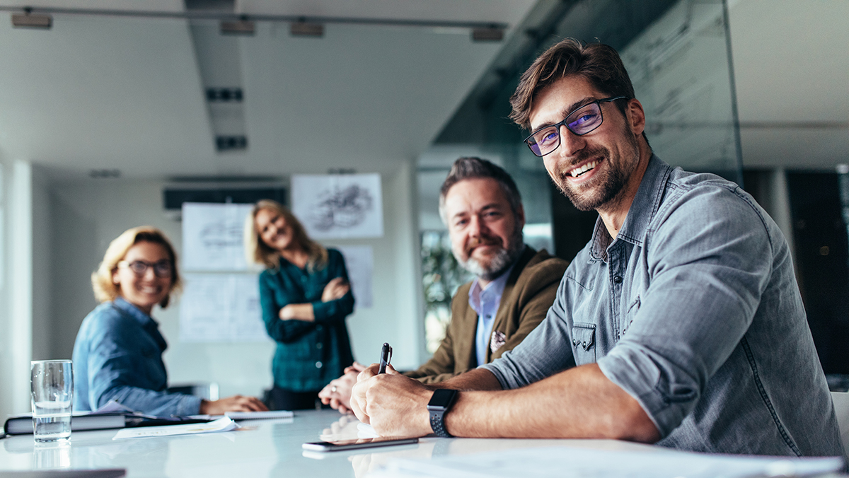 Fire personer omkring skrivebord